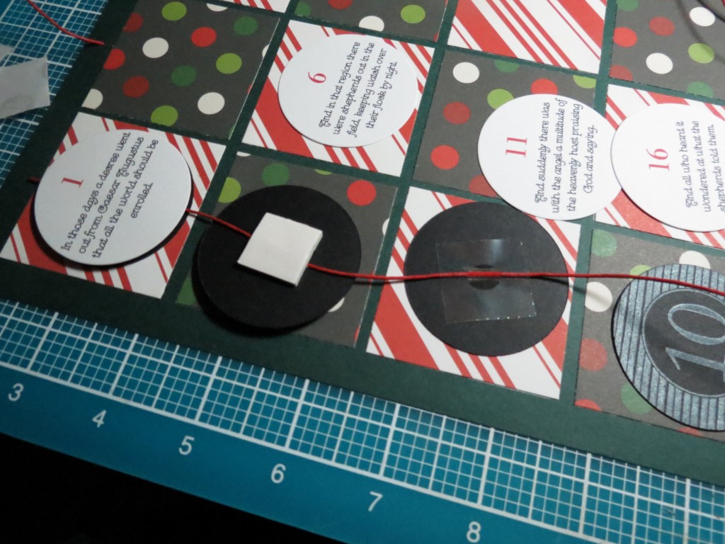 Countdown to Christmas: Three steps: first glue dot to secure cording, cover with a square of foam mounting tape and finally, cover with the advent story disc and press together.