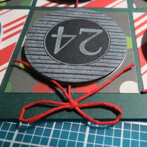 Countdown to Christmas: Bow secured with a glue dot place directly over the hole. 