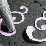 Embellishing Your Scrapbook Pages: Using embossing tool on backside of punched swirl to create dimension.  
