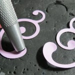 Embellishing Your Scrapbook Pages: Using embossing tool on backside of punched swirl to create dimension.