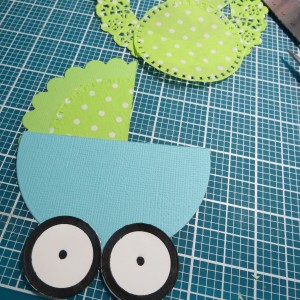 Baby Shower Scrapbook Ideas: Scored the canopy from the outside scallops, added a dotted doily for color and interest and attached wheels.