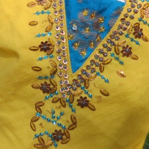 Detail shot of bead work on the outfit top.